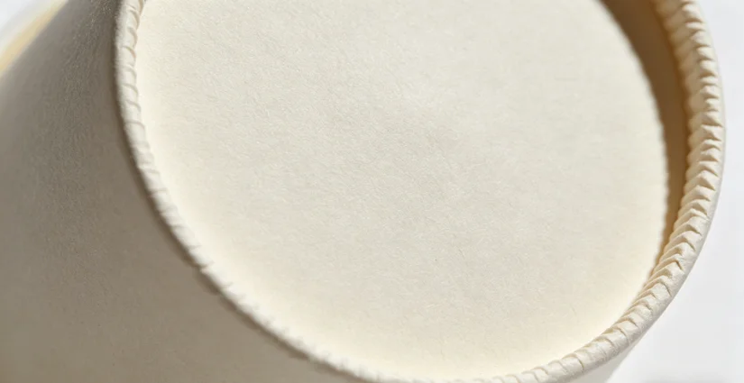 Close-up of a paper cup bottom with uneven knurling pattern – one side deeper than the other